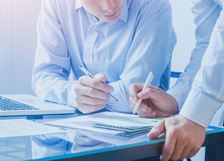 two men working on documents in a company's headquarter